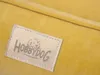 A close-up of a yellow dog bed with a brand tag. Náhľad obrázku produktu