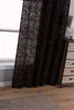 A brown patterned curtain hangs next to a window, with a wooden dresser and a rug visible in the room. Produktbild-Vorschau