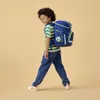 A young boy walks with a backpack. Produktbild-Vorschau