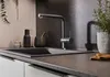 A modern kitchen sink area with a faucet, soap dispenser, mortar and pestle, and a potted plant. Anteprima dell’immagine prodotto