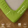 Close-up of a green fitted sheet corner showing elastic and texture. Produktbild-Vorschau