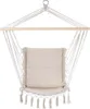 A beige hammock chair with a cushion, suspended from a wooden bar and a metal ring. Náhled obrázku produktu