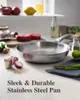 A stainless steel frying pan is displayed on a kitchen counter with ingredients like raw meat, radishes, and asparagus. Produktbild-Vorschau