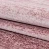 A close-up view of a folded pink carpet with a textured, mottled pattern. Voir les images du produit