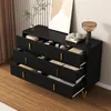 A black dresser with gold handles and legs, with several drawers open to reveal contents, set against a light-colored, striped wall. Podgląd zdjęcia produktu