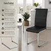 A black dining chair with a silver frame is shown in a modern dining room setting, next to a white table with a plant and a mug. Produktbild-Vorschau