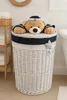A teddy bear dressed as a sailor peeks out of a white wicker laundry basket with a navy blue trim. Anteprima dell’immagine prodotto