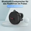 A black Bluetooth speaker with a handlebar mount is displayed on a white pedestal against a light blue and gray background. Produktbild-Vorschau
