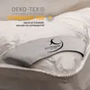 Close-up of a white duvet with a branded label. Produktbild-Vorschau