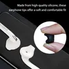 Close-up of white Samsung earphones with a small inset showing a black earphone tip being held by fingers. Produktbild-Vorschau