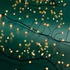 A close-up shot of a string of warm white LED lights on a black wire against a teal background. Produktbild-Vorschau