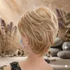 Hinterkopf einer Person mit kurzer, geschichteter blonder Perücke, mit Spa-Elementen im Hintergrund Voir les images du produit