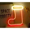 A neon Christmas stocking decoration is displayed next to a framed poster. Voir les images du produit