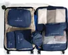 An open suitcase filled with navy blue packing cubes and folded clothes. Anteprima dell’immagine prodotto