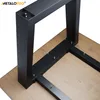 Close-up view of black metal table legs attached to a wooden tabletop. Produktbild-Vorschau