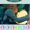 A child sleeping with a dinosaur-shaped night light. Voir les images du produit