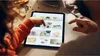 A child and an adult are looking at a tablet, likely a recipe or cooking app. Produktbild-Vorschau
