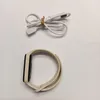 A white fitness tracker and its charging cable are laid out on a white background. Náhľad obrázku produktu