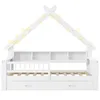 A white house-shaped bed frame with integrated shelving and drawers, decorated with string lights. Produktbild-Vorschau