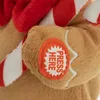 A close-up of a plush gingerbread man toy with a "PRESS HERE" button. Voir les images du produit