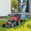 A person is mowing a lawn with a red and black gas-powered lawnmower. Produktbild-Vorschau