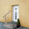A stainless steel handrail and steps leading to a white door, with a small potted plant next to the door. Náhled obrázku produktu