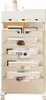 A beige mobile storage cart with multiple shelves and drawers, filled with books and tablets. Produktbild-Vorschau