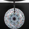 A decorative ceramic sink with a colorful mosaic pattern, suspended from a black fixture against a black background. Náhled obrázku produktu