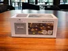A product box for LED rice lights sits on a wooden table. Produktbild-Vorschau