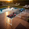 A beer pong table set up outdoors by a swimming pool at sunset. Náhled obrázku produktu