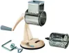 A beige and silver manual grater with a detachable drum and a clamp. Produktbild-Vorschau