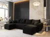 A modern living room with a large black sectional sofa, decorative wall paneling, and a crystal chandelier.