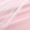 A close-up view of pink fabric with a white lace trim and a layer of white tulle. Produktbild-Vorschau