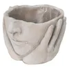 A planter shaped like a face with hands cupping the cheeks. Náhled obrázku produktu