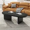 A modern living room scene featuring a black oval coffee table in front of a tan leather sectional sofa. Voir les images du produit