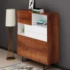 A modern cabinet with wood-grain finish and white accents, placed next to a floor lamp in a room. Produktbild-Vorschau