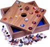 A wooden board game with colorful gemstone pieces and a die, placed inside a wooden box. Many loose gemstone pieces are scattered around the box. Produktbild-Vorschau