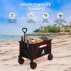 A folding wagon on a beach with a coastal town in the background. Produktbild-Vorschau