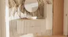 A modern bathroom vanity with a sink and mirror, set against a tropical leaf wallpaper. Podgląd zdjęcia produktu