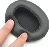 A close-up shot of a black headphone earpad being pressed by two fingers. Podgląd zdjęcia produktu