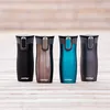 Four Contigo travel mugs are lined up on a wooden surface. Anteprima dell’immagine prodotto