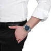 A man wearing a white dress shirt and black pants, with a watch on his left wrist. Náhled obrázku produktu