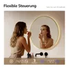 A woman is applying makeup in front of a lighted mirror. The bottom of the image shows digital readouts for time, temperature, and a timer. Produktbild-Vorschau