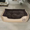 A dog bed placed on a wooden floor in a room with a fireplace and flowers. Anteprima dell’immagine prodotto