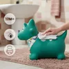 A green inflatable dinosaur toy is being wiped with a cloth in a bathroom setting. Podgląd zdjęcia produktu