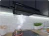 A kitchen scene with a range hood over a stovetop where food is cooking. Produktbild-Vorschau