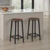 Two bar stools in a kitchen setting with a counter and fruit bowl. Náhled obrázku produktu