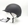 A black riding helmet displayed on a white mannequin head against a white background. Produktbild-Vorschau