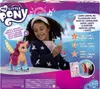 A young girl is holding a toy microphone and interacting with a My Little Pony toy on its roller skates. The packaging is colorful and features graphics related to music and movement. Produktbild-Vorschau