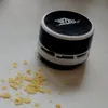 A small, black and white desktop vacuum cleaner sits on a white surface next to a pile of yellow crumbs. Anteprima dell’immagine prodotto